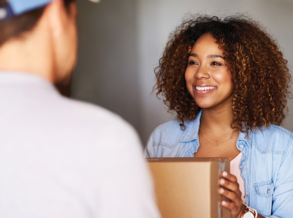 a lady receiving a next day delivery parcel from a courier